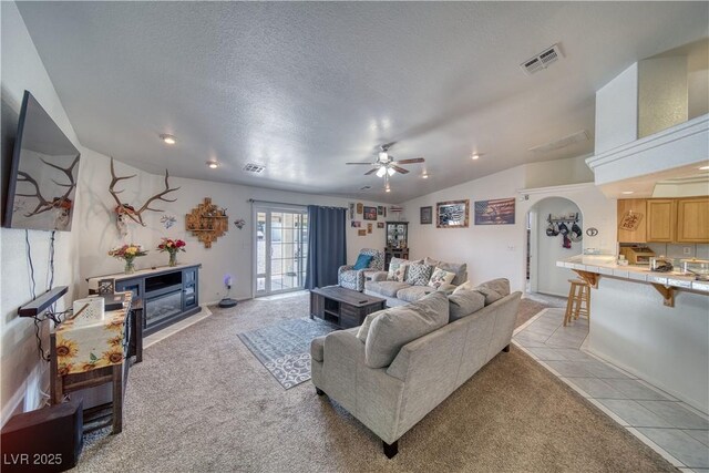 3581 Margarita Ave, Pahrump, NV 89048 - living room with lofted ceiling, light colored carpet, ceiling fan, a fireplace, and a textured ceiling