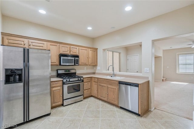 kitchen featuring stainless steel appliances, a sink, light countertops, light tile patterned floors, and recessed lighting