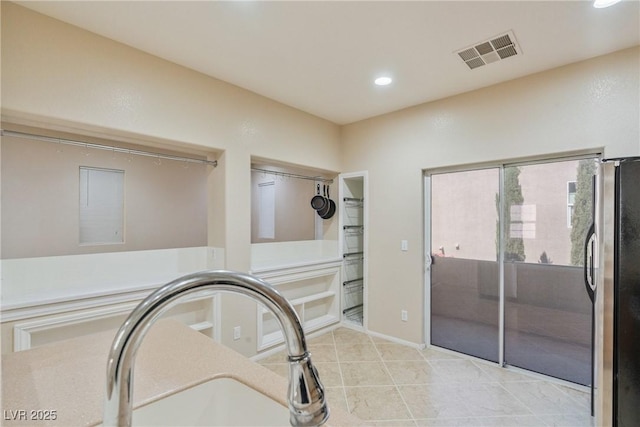 detailed view of freestanding refrigerator and recessed lighting