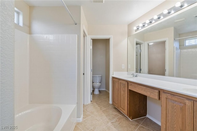 bathroom with toilet, tile patterned flooring, plenty of natural light, and double vanity