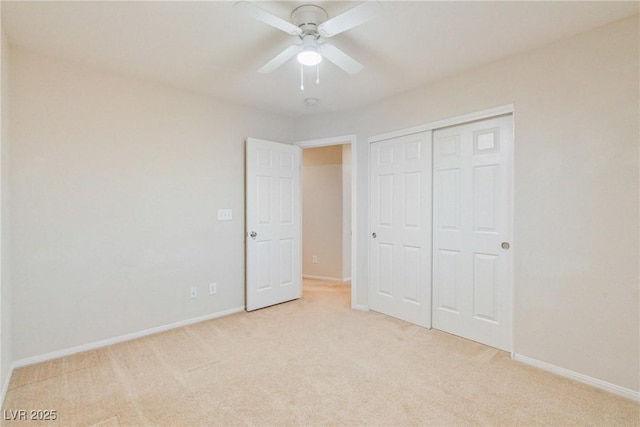unfurnished bedroom with light carpet, baseboards, a closet, and a ceiling fan