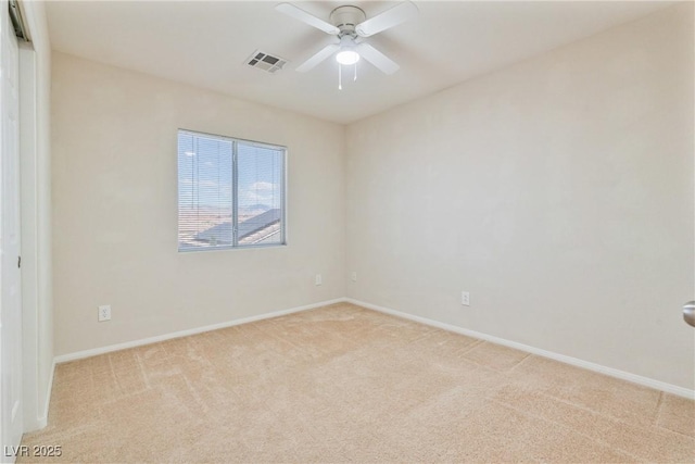 empty room with light colored carpet, baseboards, and a ceiling fan