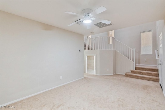 unfurnished living room with stairs, a ceiling fan, carpet floors, and baseboards