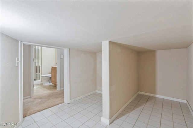basement with baseboards and light tile patterned floors