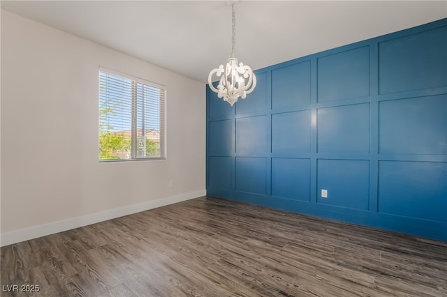 133 Clouded Ave, Henderson, NV 89002 - unfurnished room featuring a chandelier, a decorative wall, dark wood finished floors, and baseboards