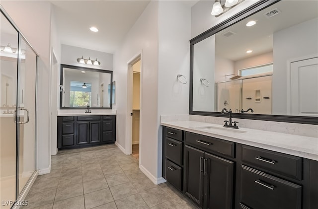 133 Clouded Ave, Henderson, NV 89002 - bathroom with a shower stall, two vanities, tile patterned floors, baseboards, and a spacious closet