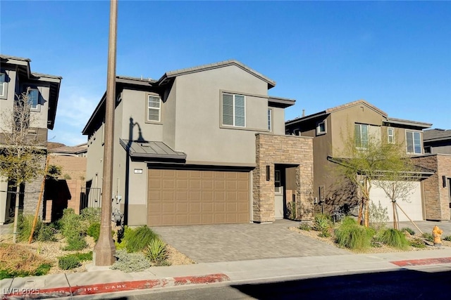 40 Strada Moscato, Henderson, NV 89011 - view of front of home with stucco siding, a garage, stone siding, driveway, and a standing seam roof