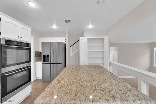 2257 Norway Pine Ct, Las Vegas, NV 89134 - kitchen with appliances with stainless steel finishes, light stone counters, white cabinets, recessed lighting, and tile patterned flooring