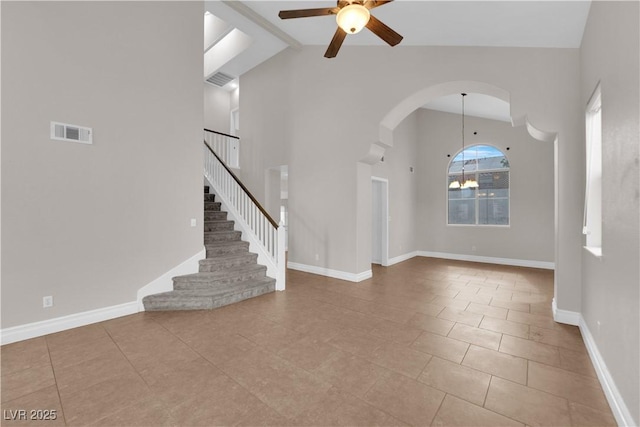 2257 Norway Pine Ct, Las Vegas, NV 89134 - unfurnished living room with a ceiling fan, arched walkways, high vaulted ceiling, stairway, and baseboards