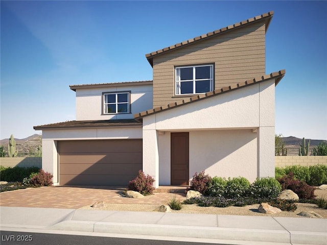 310 La Musica Pl, Henderson, NV 89015 - view of front of property with a tiled roof, an attached garage, decorative driveway, fence, and stucco siding