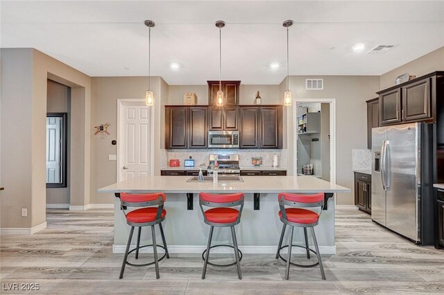 468 Harvest Rain, Las Vegas, NV 89011 - kitchen featuring stainless steel appliances, light countertops, light wood-type flooring, and decorative backsplash
