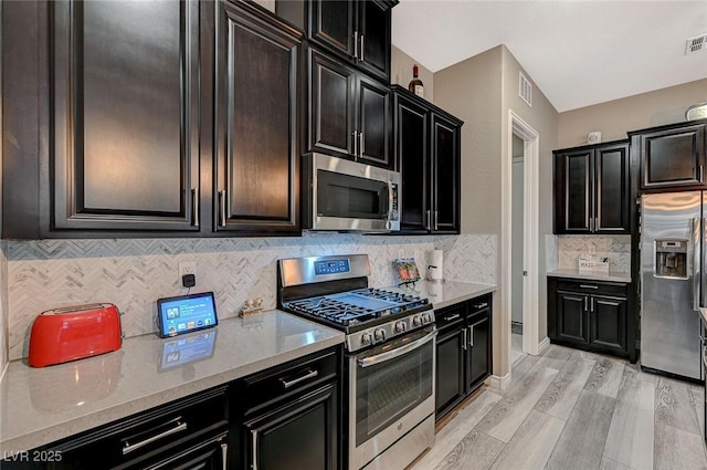 468 Harvest Rain, Las Vegas, NV 89011 - kitchen with appliances with stainless steel finishes, backsplash, light wood-style flooring, and dark cabinets