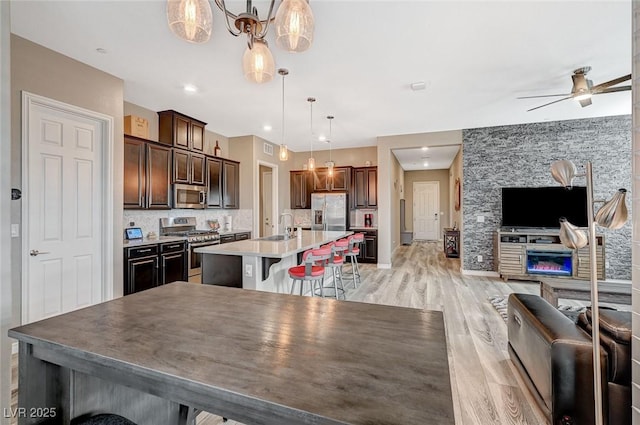 468 Harvest Rain, Las Vegas, NV 89011 - kitchen featuring stainless steel appliances, open floor plan, a sink, a breakfast bar area, and ceiling fan