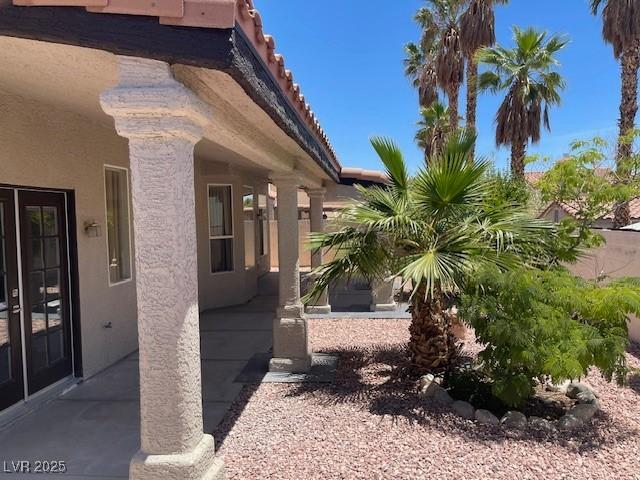 8847 W Katie Ave, Las Vegas, NV 89147 - view of side of home with stucco siding, a tile roof, and a patio area