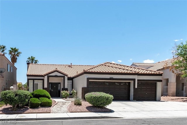 8847 W Katie Ave, Las Vegas, NV 89147 - view of front facade with an attached garage, stucco siding, driveway, and a tiled roof