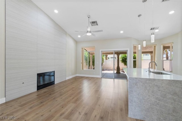 8847 W Katie Ave, Las Vegas, NV 89147 - unfurnished living room with a sink, a tiled fireplace, baseboards, wood finished floors, and recessed lighting