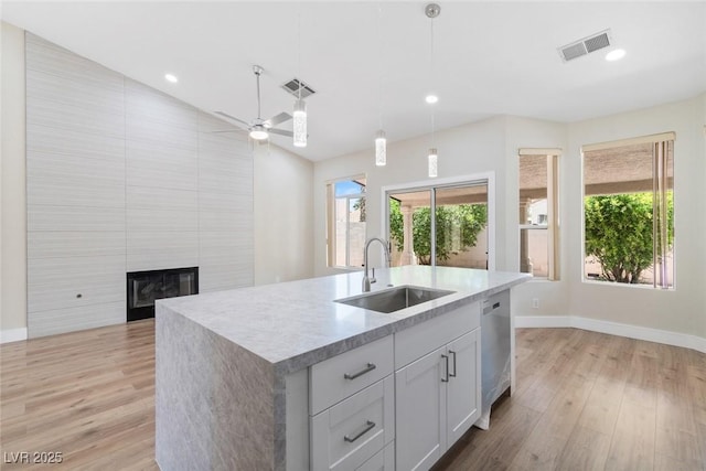 8847 W Katie Ave, Las Vegas, NV 89147 - kitchen featuring a sink, stainless steel dishwasher, a large fireplace, light countertops, and baseboards