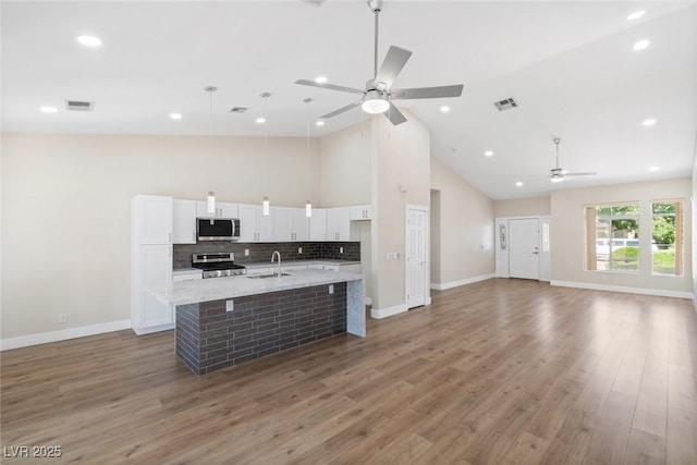 8847 W Katie Ave, Las Vegas, NV 89147 - kitchen featuring stainless steel appliances, ceiling fan, a sink, high vaulted ceiling, and white cabinetry