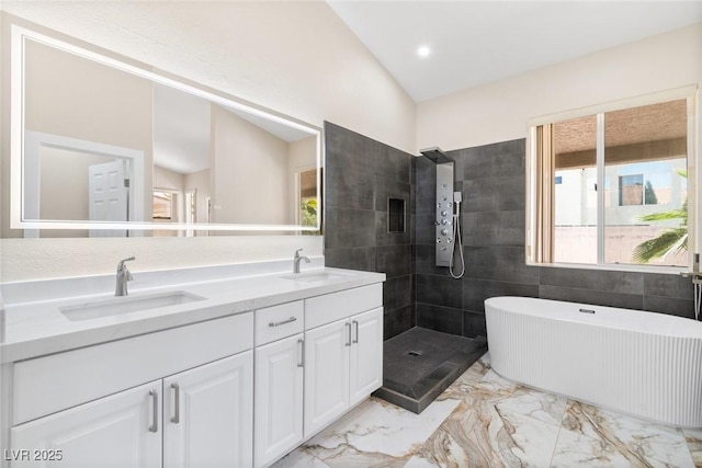 8847 W Katie Ave, Las Vegas, NV 89147 - full bath featuring radiator, marble tiled flooring, a freestanding tub, double vanity, and vaulted ceiling