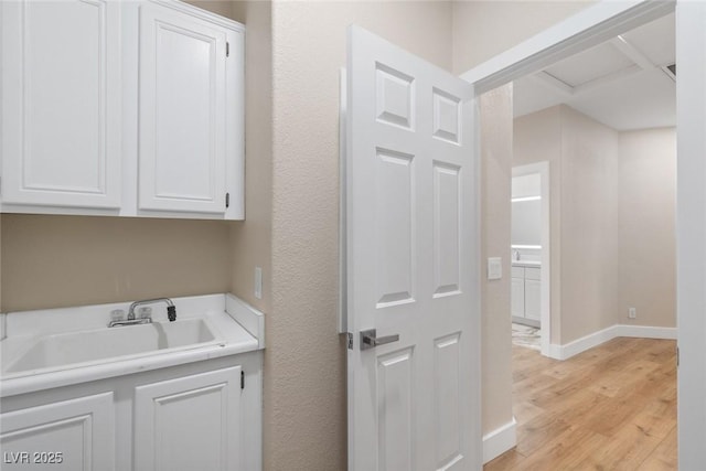 8847 W Katie Ave, Las Vegas, NV 89147 - laundry area with a sink, light wood finished floors, and baseboards