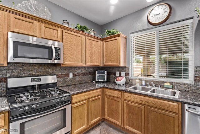 3005 Dotted Wren Ave, North Las Vegas, NV 89084 - kitchen with appliances with stainless steel finishes, a sink, tasteful backsplash, and dark stone countertops