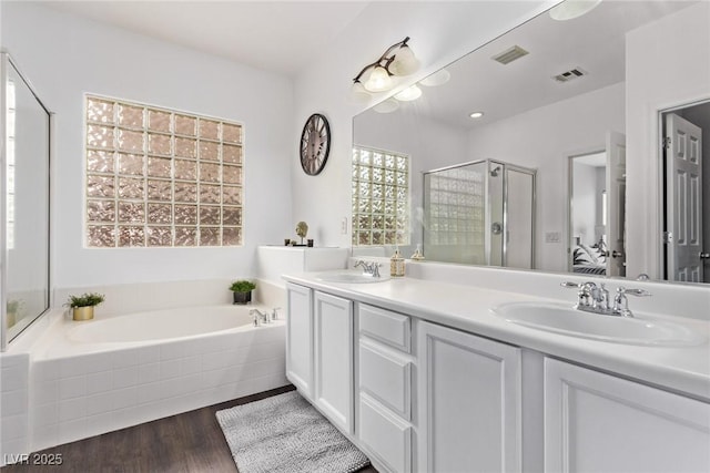 3005 Dotted Wren Ave, North Las Vegas, NV 89084 - bathroom with a garden tub, a shower stall, wood finished floors, and double vanity