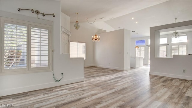 4653 Califa Dr, Las Vegas, NV 89122 - unfurnished room featuring a chandelier, a ceiling fan, light wood finished floors, vaulted ceiling, and baseboards