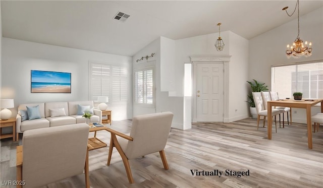 4653 Califa Dr, Las Vegas, NV 89122 - living area featuring vaulted ceiling, a chandelier, light wood finished floors, and baseboards