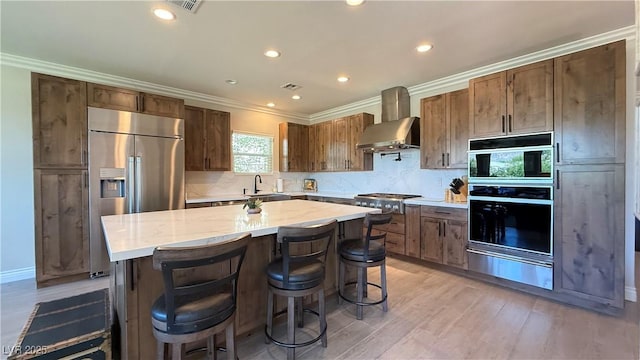 4299 Fiore Bella Blvd, Las Vegas, NV 89135 - kitchen with wall chimney exhaust hood, a warming drawer, a sink, appliances with stainless steel finishes, and tasteful backsplash