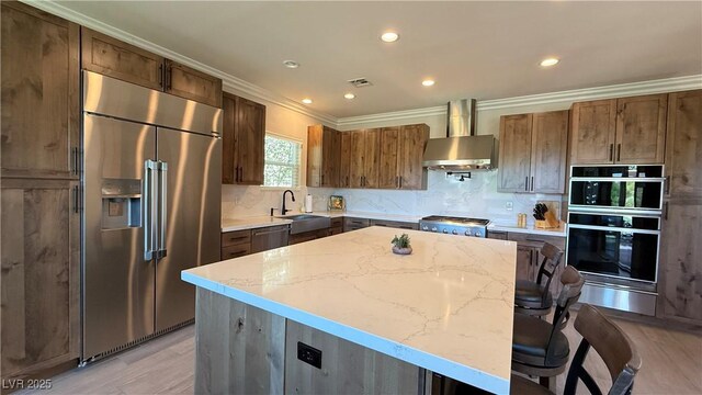 4299 Fiore Bella Blvd, Las Vegas, NV 89135 - kitchen featuring stainless steel appliances, wall chimney range hood, a warming drawer, ornamental molding, and a sink