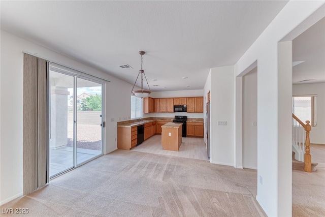 kitchen with black appliances, light colored carpet, open floor plan, and light countertops