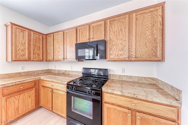kitchen featuring black appliances and tile counters