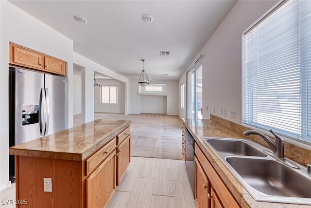 kitchen with a sink, tile counters, plenty of natural light, and dishwasher
