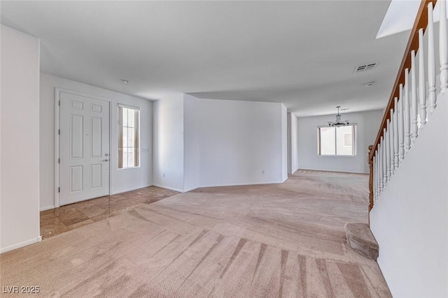 entrance foyer with carpet, stairway, a chandelier, and baseboards