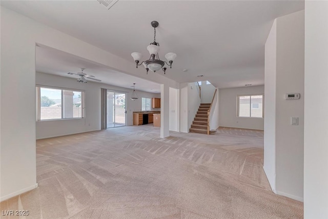 unfurnished living room featuring light colored carpet, a chandelier, stairs, and baseboards