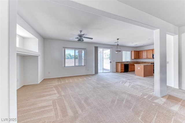 unfurnished living room featuring baseboards, light colored carpet, and a ceiling fan