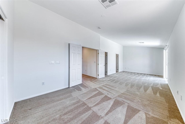 unfurnished room with light carpet and baseboards