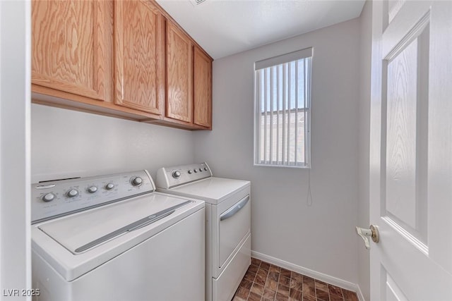 laundry room with independent washer and dryer, baseboards, and cabinet space
