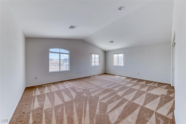 carpeted spare room featuring vaulted ceiling, baseboards, and a smoke detector