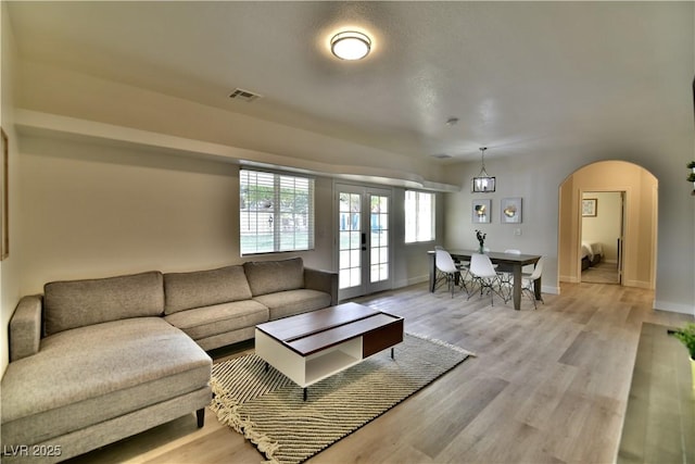 2926 E Eldorado Ln, Las Vegas, NV 89120 - living area featuring arched walkways, light wood finished floors, french doors, and baseboards