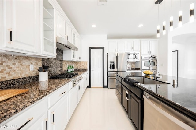 8244 Cupertino Heights Way, Las Vegas, NV 89178 - kitchen with under cabinet range hood, appliances with stainless steel finishes, white cabinetry, dark stone counters, and recessed lighting