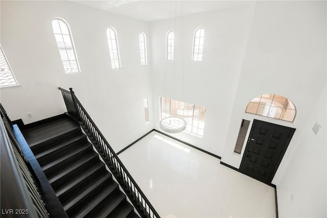 8244 Cupertino Heights Way, Las Vegas, NV 89178 - staircase featuring a high ceiling, wood finished floors, and baseboards