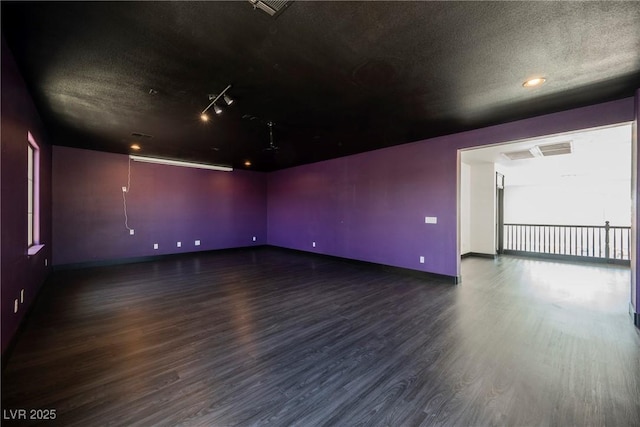 8244 Cupertino Heights Way, Las Vegas, NV 89178 - empty room with wood finished floors, a textured ceiling, baseboards, and rail lighting