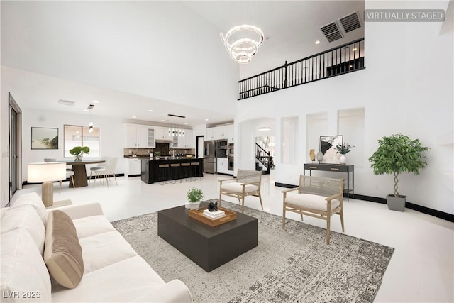 8244 Cupertino Heights Way, Las Vegas, NV 89178 - living room with a chandelier, stairs, a towering ceiling, and recessed lighting