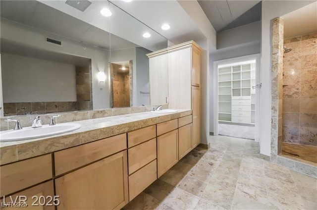 360 E Desert Inn Rd Unit 807, Las Vegas, NV 89109 - bathroom featuring tiled shower, double vanity, a walk in closet, and recessed lighting