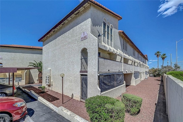 view of home's exterior with stucco siding and fence