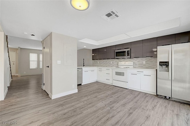 kitchen featuring appliances with stainless steel finishes, light countertops, modern cabinets, decorative backsplash, and light wood-style floors