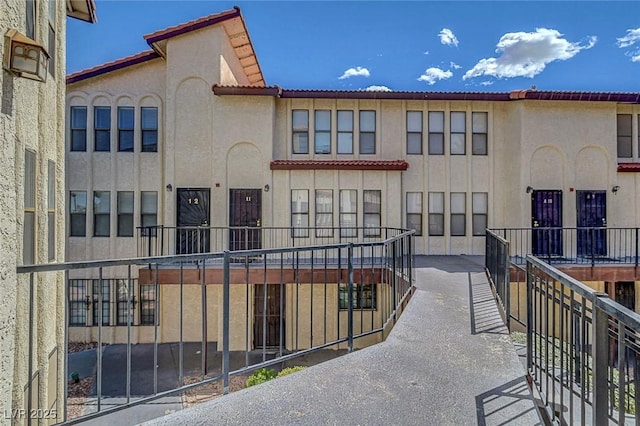 view of front of home featuring stucco siding, a tile roof, and a balcony