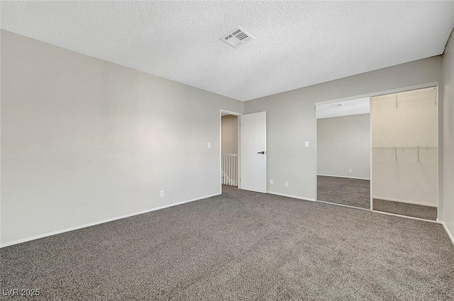 unfurnished bedroom with carpet, a textured ceiling, baseboards, and a closet
