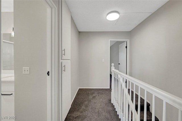hall featuring carpet floors, an upstairs landing, and baseboards